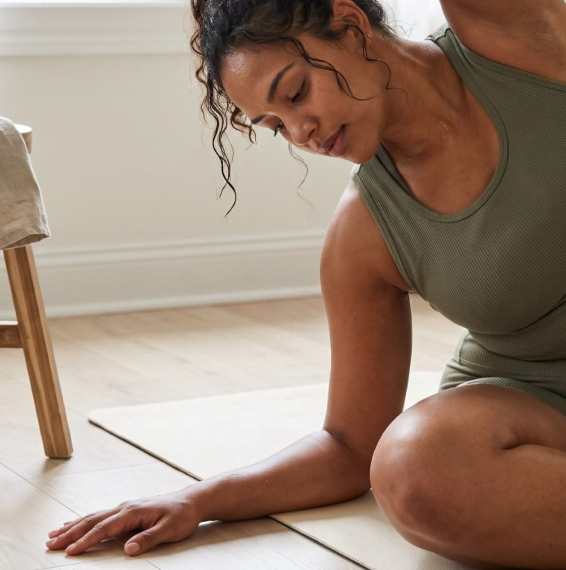 Woman mid-stretch during a home yoga flow in natural light