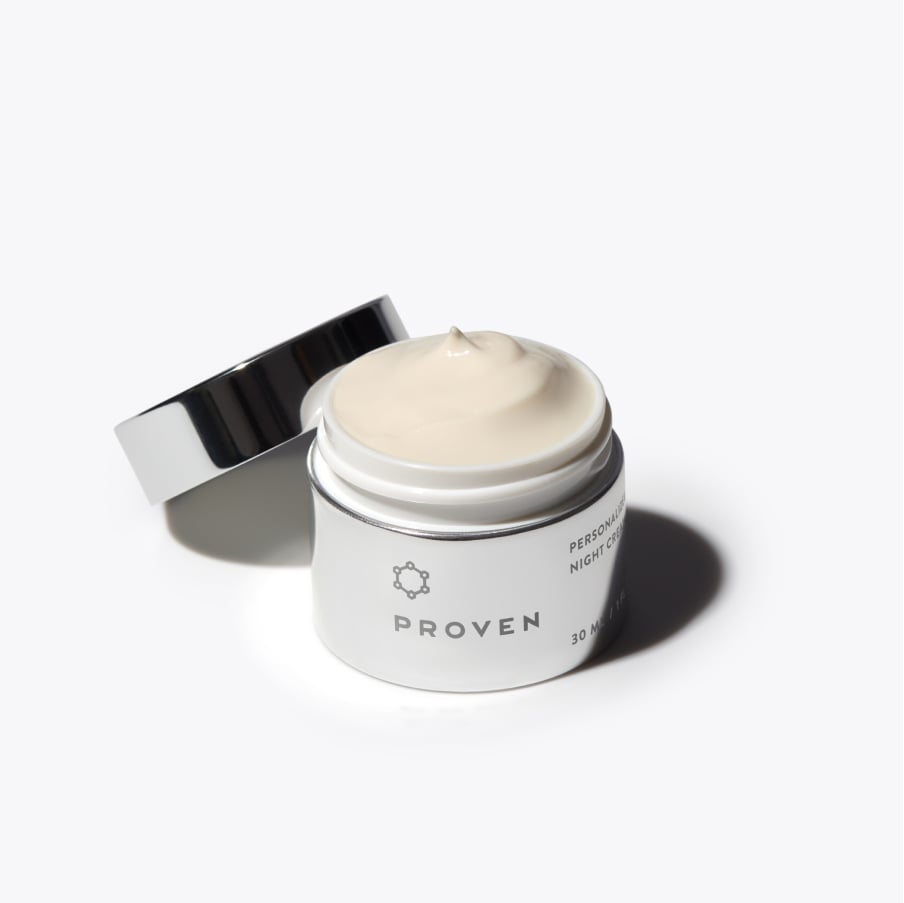The same jar open with its cap leaning against it, showing the cream inside.
