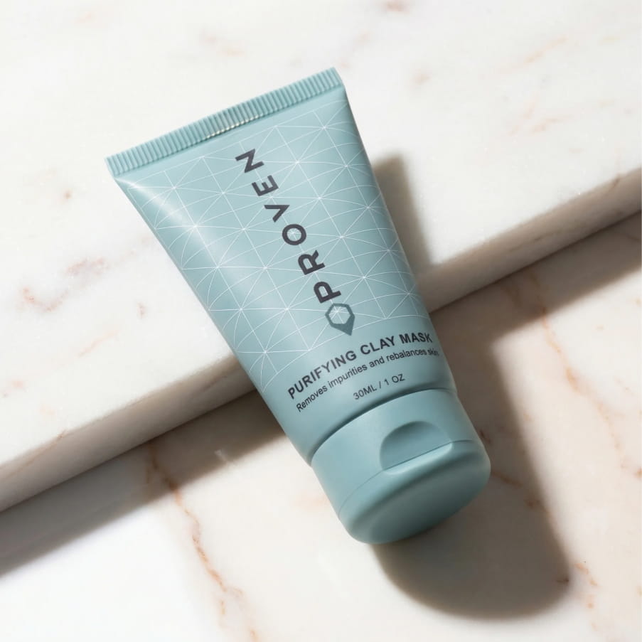 The Purifying Clay Mask tube lying on a sunlit marble surface