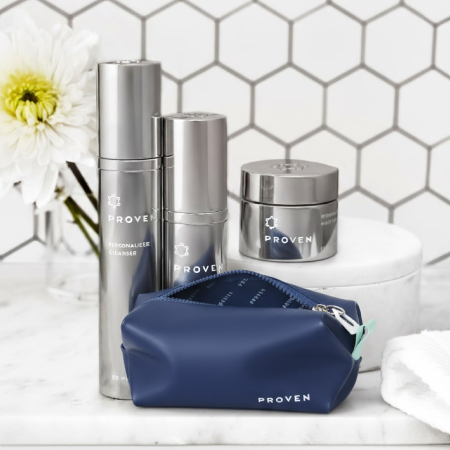 The bag zipped shut on a marble bathroom counter next to the silver PROVEN bottles and a vase of white flowers.