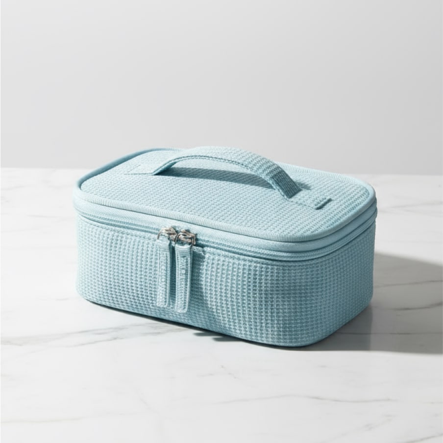 The bag closed on a marble surface, showing its waffle-weave texture and top carry handle.
