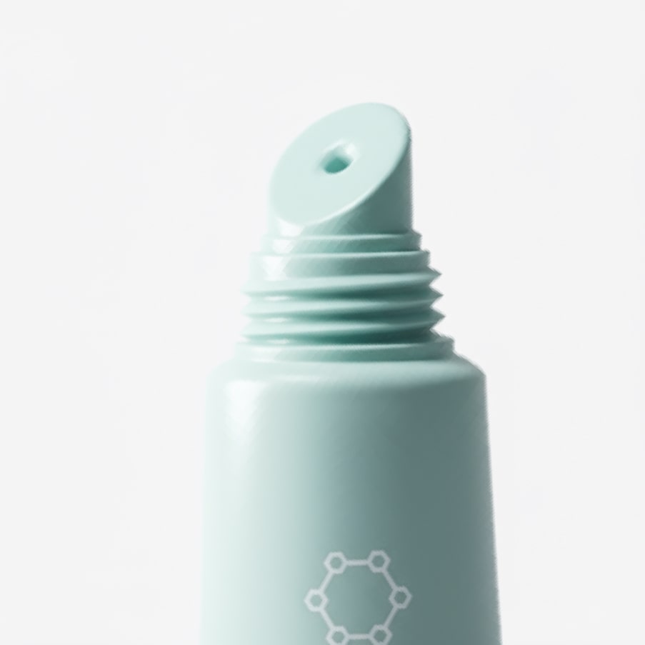 A close-up of the tube's open nozzle and threaded neck.