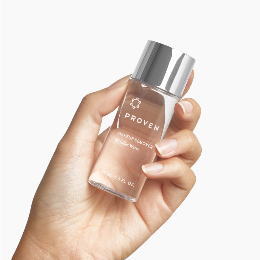 A hand holding the micellar water bottle, showing its travel size.
