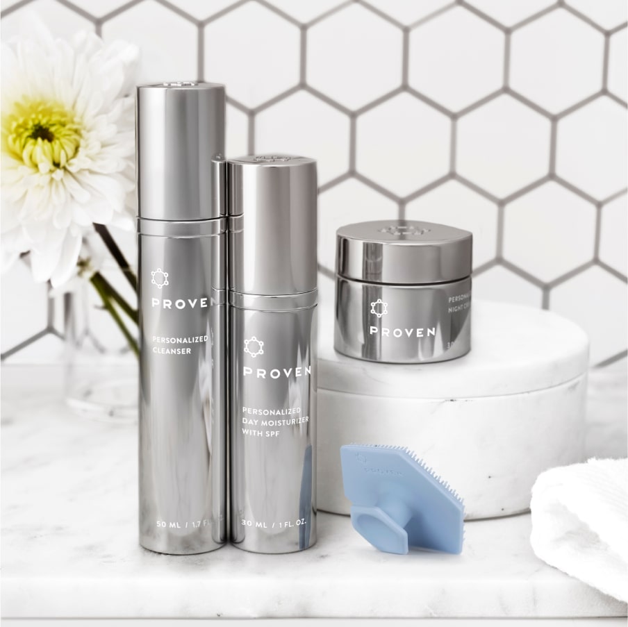 The pad on a marble bathroom shelf beside the PROVEN cleanser, day moisturizer and night cream